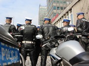 stojący tyłem policjanci w mundurach motocyklowych