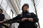 policjantka w mundurze i kasku stoi ze swoim rowerem - zdjęcie zrobione od dołu
