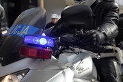 zbliżenie kierownicy motocykla policyjnego i ręki policjanta na manetce