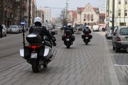 trzech policjantów jedzie na motocyklach po ulicy - ujęcie od tyłu