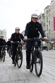 dwie policjantki  jadą na rowerach policyjnych ulicami miasta
