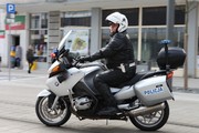 policjant ruchu drogowego jedzie na policyjnym motocyklu po ulicy w mieście