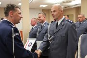 Komendant Wojewódzki Policji w Poznaniu insp. Piotr Mąka wręcza rozkaz policjantowi