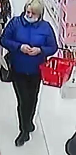 wizerunek kobiety podejrzewanej o dokonanie kradzieży. kobieta ma krótkie blond włosy, niebieską kurtkę, czarne spodnie. na twarzy maseczkę.