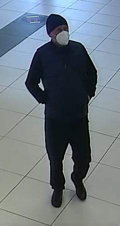 mężczyzna w wieku około 45 lat, normalnej budowy ciała, ubrany w czarną, zimową czapkę, granatowy pikowany bezrękawnik, ciemną bluzę oraz spodnie, na twarzy ma maseczkę zasłaniająca usta i nos