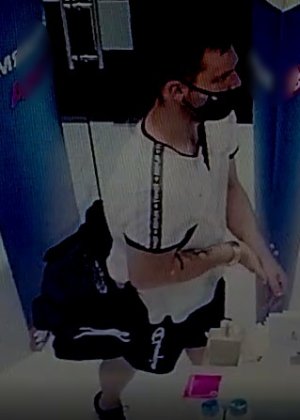 mężczyzna na krótkie ciemne włosy, białą koszulkę typu tshirt, czarną torbę przewieszoną przez ramię