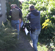 Mężczyzna wskazuje policjantom miejsce ukrycia hulajnogi.